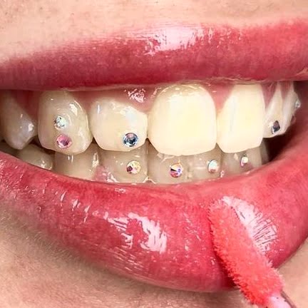 Obrazek przedstawia kolorowe kryształki tooth gems na zębach